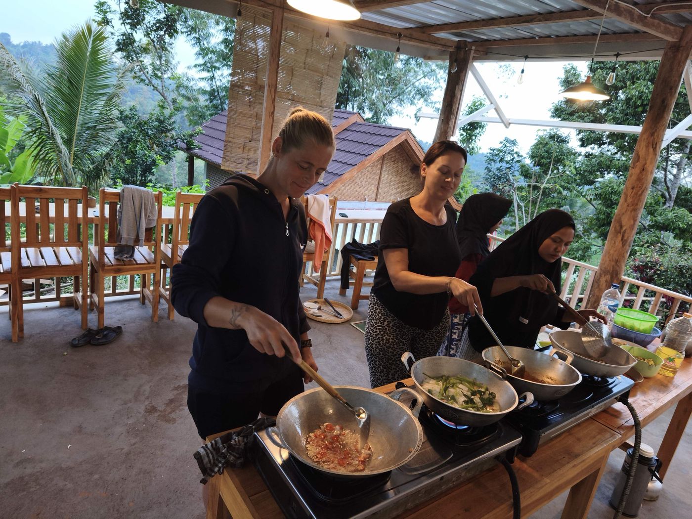 Guests and the family cooking together on the terrace